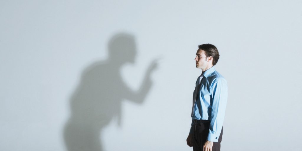 Man being scolded by his shadow